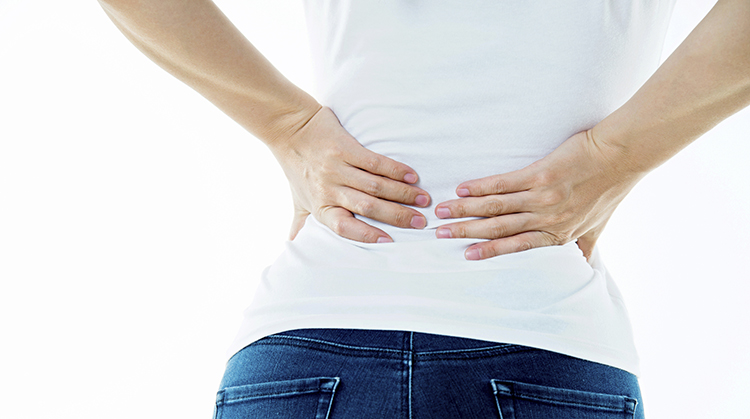 A woman with her hands on her lower back